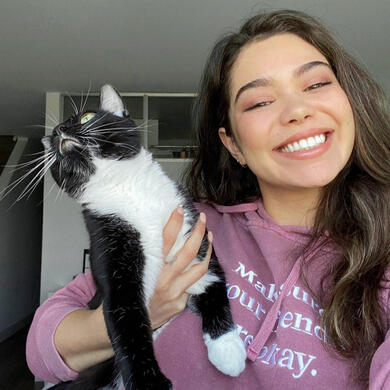 Auli'i Cravalho holding a cat. Her shirt says "make sure your friends are okay" Auli'i Cravalho holding a cat. Her shirt says "make sure your friends are okay"